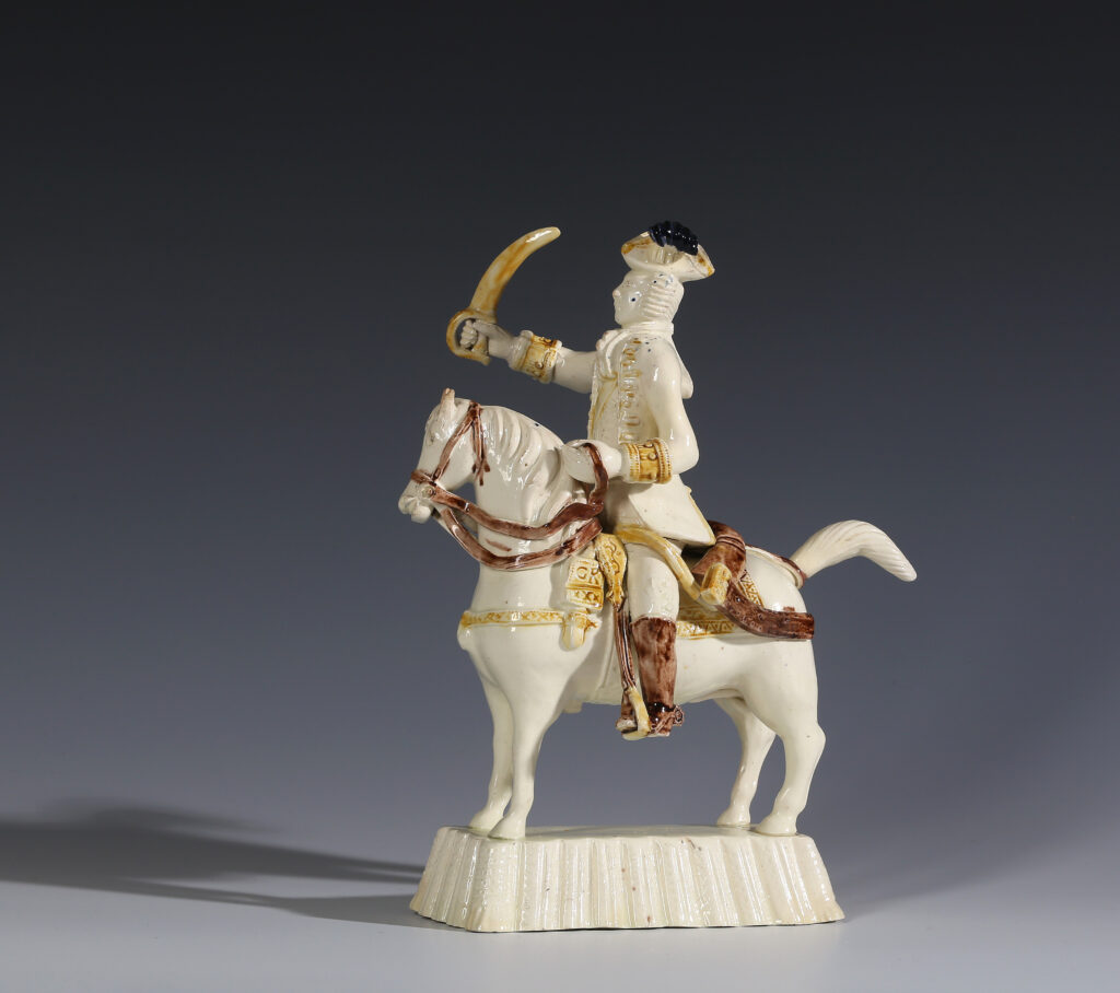 A CREAMWARE FIGURE OF A MOUNTED OFFICER