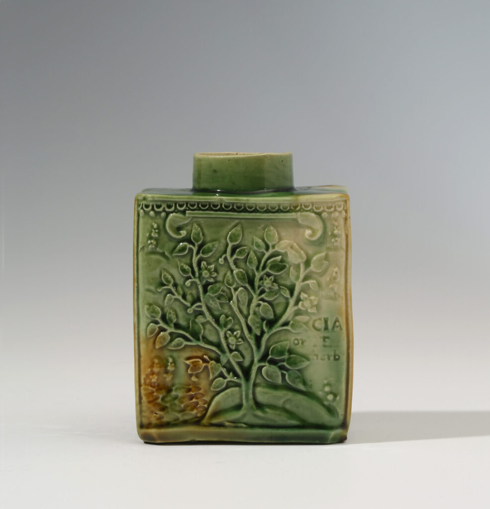 A GREEN AND OCHRE GLAZED STAFFORDSHIRE CREAMWARE TEA CADDY