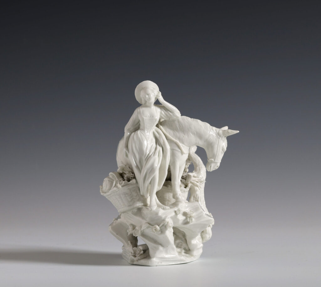 A TOURNAI PORCELAIN FIGURE OF A MARKET GIRL WITH A DONKEY